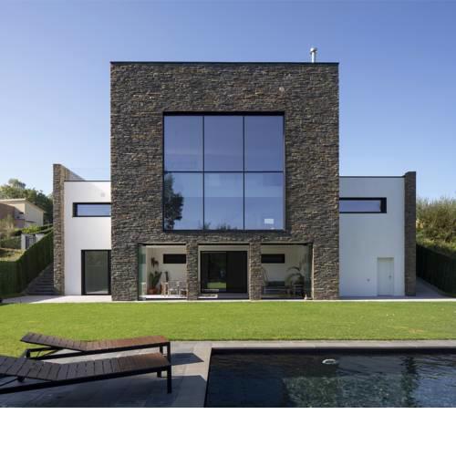 Casa moderna con piscina y vistas al bosque.