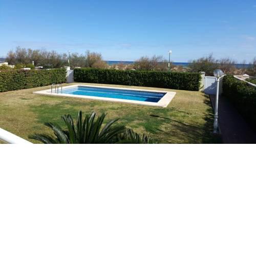primera línea de la playa de oliva con jardín y piscina.